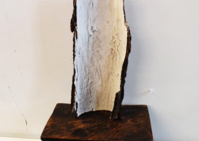 a bark sculpture on a milking stool
