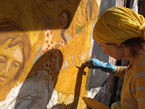 painting a section of fresco on yellow lime mortar
